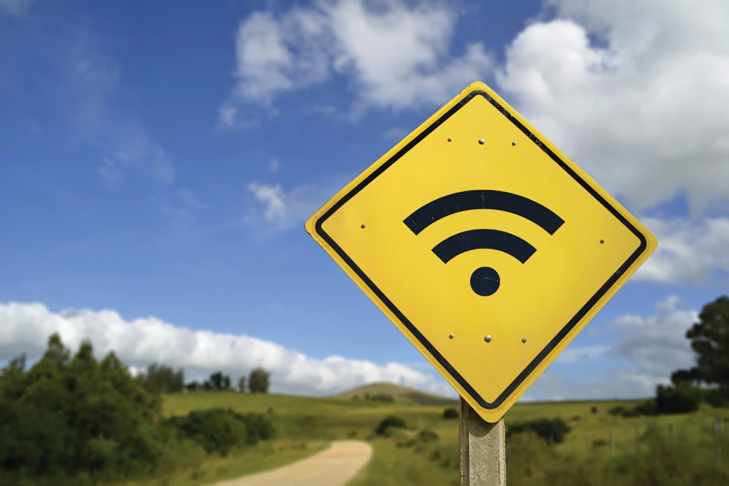 Internet access in remote zone, power of technology concept. Road sign with wifi signal icon on rural environment, includes copy space.